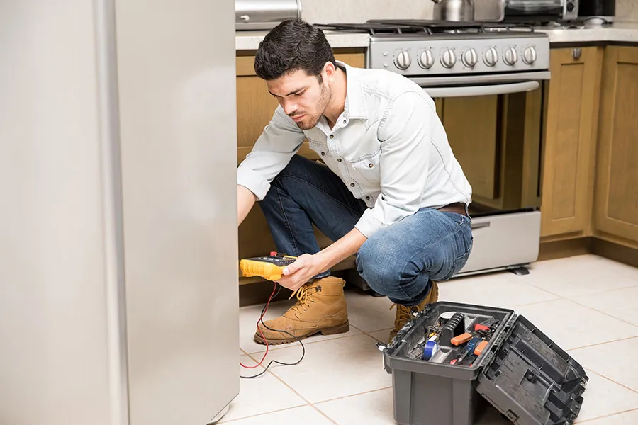 Appliance repair technician diagnosing a refrigerator problem in a residential kitchen — representing how SEO and AI search visibility help homeowners discover local appliance repair companies with the right service expertise.