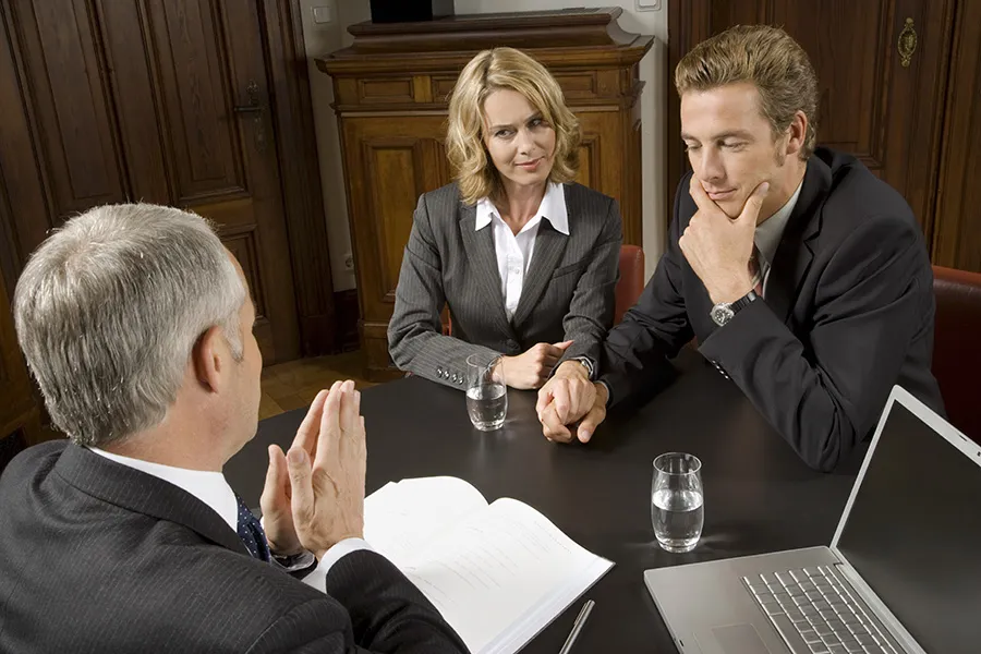 Attorney advising a couple during a private consultation — representing family law practices seeking greater visibility for divorce, child custody, adoption, prenuptial agreements, and related legal services.