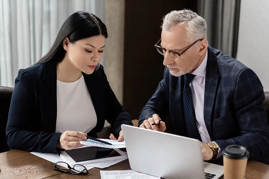Two professionals reviewing information and charts together — representing law firm SEO strategies that evaluate website visitor activity, improve conversion opportunities, and turn search visibility into more qualified client inquiries.
