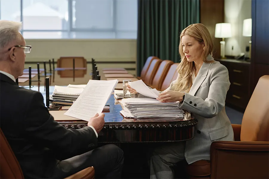 Legal professionals reviewing substantial case files and documents — representing law firm websites that organize practice areas, legal services, and attorney information to help prospective clients find the guidance they need.
