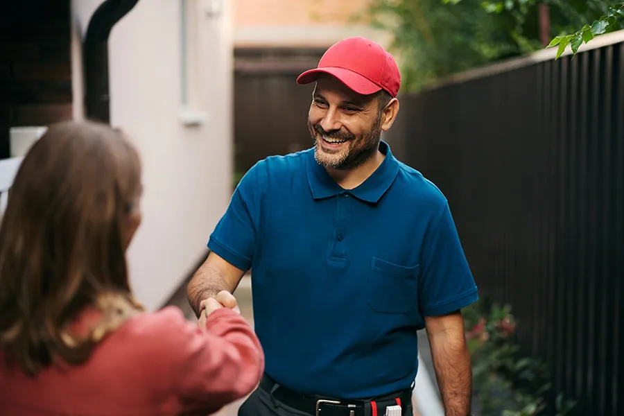 Service professional greeting a homeowner at her residence — representing how mobile service business SEO helps local customers find qualified providers, build confidence, and make contact about hiring their services.