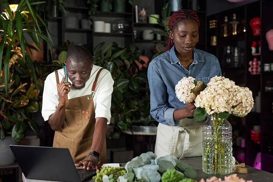 Flower shop owners managing their website orders and serving customers — representing business owners using professional web design and SEO to grow their business.